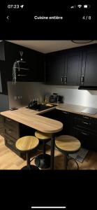 a kitchen with a wooden table and two stools at Studio a Berck proche plage in Berck-sur-Mer