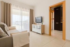 a living room with a couch and a tv at Varandas do Mar, Olhos de Agua, 1 Bed Apt AT23 in Olhos de Água