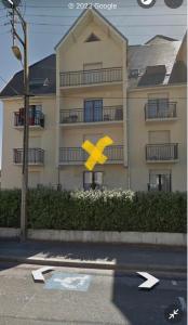 a building with a yellow arrow sign in front of it at Studio a Berck proche plage in Berck-sur-Mer