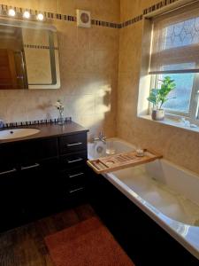 Un baño con bañera, lavabo y bañera. en Seaside retreat with hot tub, en Cleethorpes