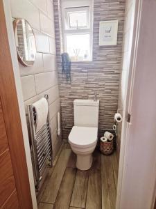 Un pequeño baño con inodoro y ventana. en Seaside retreat with hot tub, en Cleethorpes 26 fotos más