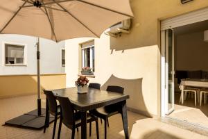 a table with chairs and an umbrella on a patio at Residence Hotel Le Stelle in Rimini