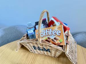 a basket filled with snacks on a table at Dudleys Retreat - Part of the The Bay Filey Holiday Village with pool, gym and direct beach access, pub, restaurant, tennis and meadows walks in Filey