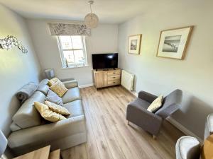 a living room with a couch and a tv at Dudleys Retreat - Part of the The Bay Filey Holiday Village with pool, gym and direct beach access, pub, restaurant, tennis and meadows walks in Filey