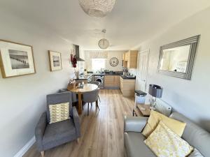 a living room with a couch and a table at Dudleys Retreat - Part of the The Bay Filey Holiday Village with pool, gym and direct beach access, pub, restaurant, tennis and meadows walks in Filey