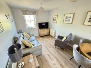 a living room with a couch and a tv at Dudleys Retreat - Part of the The Bay Filey Holiday Village with pool, gym and direct beach access, pub, restaurant, tennis and meadows walks in Filey +41 photos