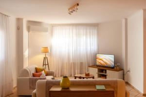 a living room with a couch and a tv at Manolia house near beach, near airport in Aghia Marina