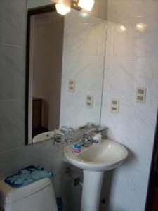 a bathroom with a sink and a toilet and a mirror at A Place in the Sky - c23 Calacoto in La Paz