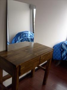 una mesa de madera con un espejo junto a la cama en A Place in the Sky - c23 Calacoto, en La Paz