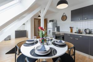 a kitchen and dining room with a white table and chairs at gemütliches Stadtloft in Dessau in Dessau