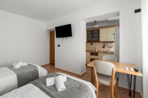 a room with two beds and a table and a kitchen at Katerina's Apartment in Berat