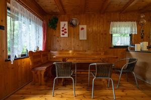 a dining room with a wooden table and chairs at Domek nad jeziorem in Kretowiny