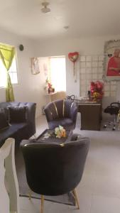 a living room with two chairs and a couch at Queen Bmazazhi Stay in San Pedro de Macorís