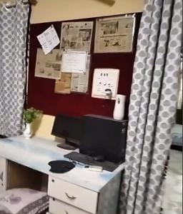 a desk with a computer monitor on top of it at Boho-themed studio apartment in Nashik