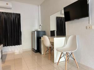 a living room with a table and two white chairs at Hatyai Bangkok Resort หาดใหญ่ บางกอก รีสอร์ท in Hat Yai