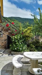 two white benches sitting on a patio with flowers at Casa David in Tríacastela