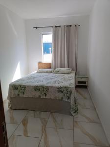 a bedroom with a bed and a window at Relaxe à Beira-Mar com pé na areia! in Tramandaí