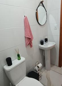 a bathroom with a toilet and a sink at Relaxe à Beira-Mar com pé na areia! in Tramandaí +9 photos