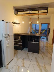 a kitchen with a white refrigerator and a counter at Relaxe à Beira-Mar com pé na areia! in Tramandaí