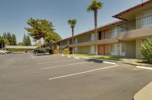 ein Parkplatz vor einem Gebäude mit Palmen in der Unterkunft Vagabond Inn Sunnyvale in Sunnyvale