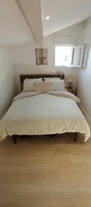 a large bed in a bedroom with a window at Maison duplex Bisca avec jardin in Biscarrosse