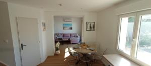 a living room with a table and a couch at Maison duplex Bisca avec jardin in Biscarrosse