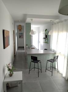 a kitchen with two chairs and a table in it at Ático Sol & Mar - La Línea in La Línea de la Concepción