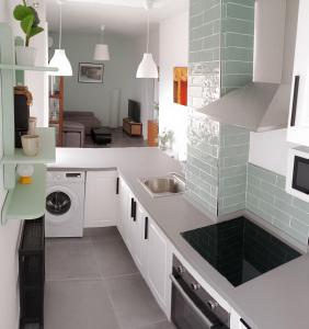 a white kitchen with a sink and a dishwasher at Ático Sol & Mar - La Línea in La Línea de la Concepción +26 photos