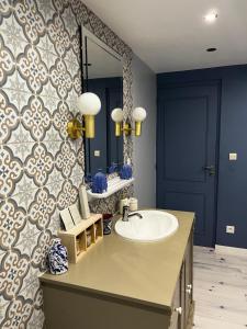 a bathroom with a sink and a mirror at Suite Une Bulle d Evidence avec baignoire spa in Saumur