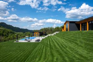 a large grassy field in front of a house at Cabana Friends in Valea Inzelului