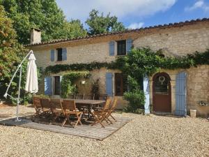 a table and chairs in front of a building at Gîte La Marteille in Saint-Privat-des-Prés