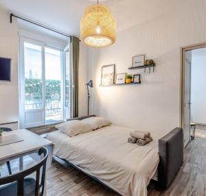 a bedroom with a bed and a table and a window at T2 centre ville, 150m du lac, parking - Thermes in Évian-les-Bains