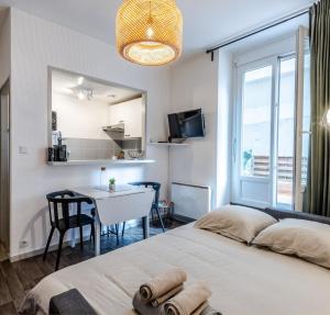 a bedroom with a bed and a table and a window at T2 centre ville, 150m du lac, parking - Thermes in Évian-les-Bains
