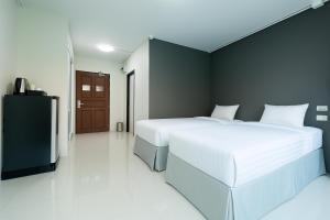 a bedroom with a white bed and a black wall at Siam Rama9 Hotel in Bangkok