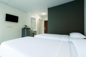 a bedroom with two beds and a flat screen tv at Siam Rama9 Hotel in Bangkok