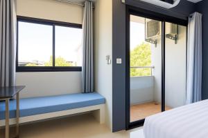 a bedroom with a window seat with a blue bench at Siam Rama9 Hotel in Bangkok