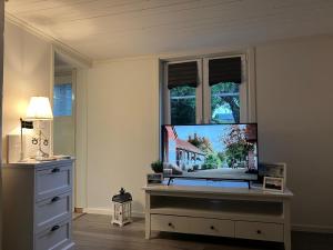 a living room with a tv and a window at Sommardröm in Västra Öskevik