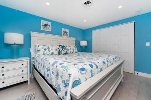 a blue bedroom with a bed and a white dresser at Seaglass Inn in Englewood