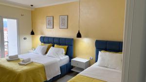 a bedroom with two beds and a window at Your Home in Pogradec