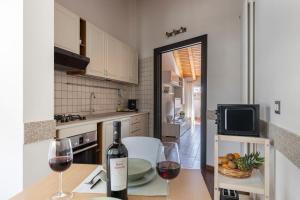 eine Küche mit einem Tisch und einer Flasche Wein in der Unterkunft SAVOIA 173 - Apartment in Acireale