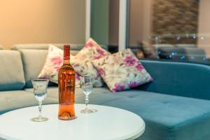 a bottle and two glasses on a table with a couch at Villa Jordan in Ohrid