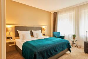 Rúm í herbergi á Best Western Premier Alsterkrug Hotel