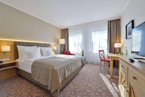 Rúm í herbergi á Best Western Premier Alsterkrug Hotel
