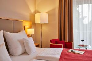 Rúm í herbergi á Best Western Premier Alsterkrug Hotel