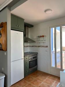 a kitchen with green cabinets and a white refrigerator at Torremar Natura 532 in Vera