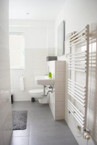 une salle de bain blanche avec un lavabo et des toilettes dans l'établissement Ruhige FeWo mit eingezäunten Garten - familienfreundlich, à Garz