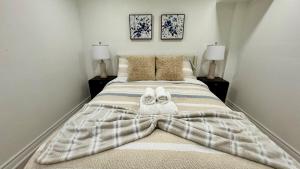 una camera da letto con un letto grande con asciugamani sopra di Cozy Hidden Gem, Stylish 2BR with Sofa Bed a Mississauga