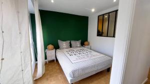 Un dormitorio con una cama grande con una pared verde. en Beau F3 Proche Paris & Orly, 6 pers - Parking - Metro 14 & RER C, en Thiais 20 fotos más