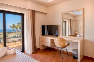 a bedroom with a television and a desk with a mirror at Bliss Villas Complex with private pool in Hersonissos