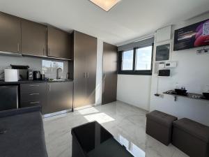 a kitchen with brown cabinets and a living room at Rooftop with 360 view in Athens